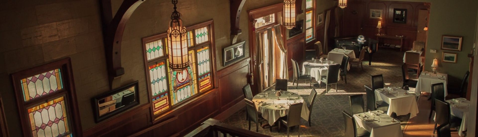 Belfry Bistro 由旧教堂改造的餐厅内景，彩色玻璃和白桌布餐桌